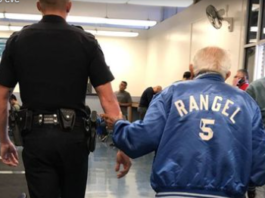 Egy idős bácsinak segít a fiatal rendőr. Hirmagazin.eu