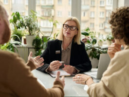 mature woman consulting couple in insurance agency