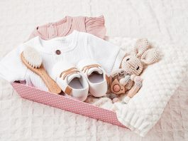 gift basket with gender neutral baby garment and accessories. care box of organic newborn cotton clothes
