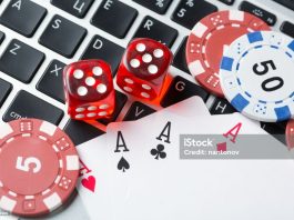 online poker casino theme. gambling chips with dice and playing cards on laptop