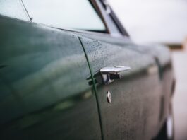 closeup shot of a green muscle car door with a blurred background
