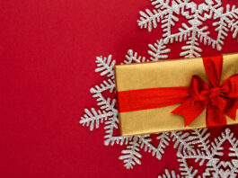 christmas, holiday present box on red background.