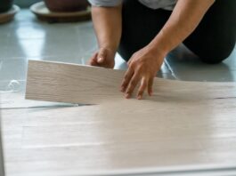 a person installing new vinyl tile floor, a diy home project.