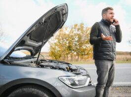 a man calls a phone number to talk to a mechanic. the car broke down on the roadside. the concept for fix, help, problem, repair. blurred background.