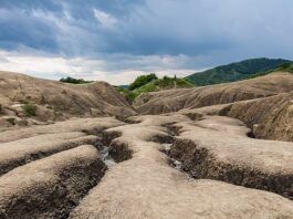 Volcanes de lodo, Buzau, Rumanía, 2016-05-29, DD 28.jpg The Berca Mud Volcanoes are a geological and botanical reservation located close to Berca in Buzău County, Romania. The phenomenon is caused due to gases that erupt from 3,000 metres (9,800 ft) deep towards the surface, through the underground layers of clay and water, they push up underground salty water and mud, so that they overflow through the mouths of the volcanoes, while the gas emerges as bubbles. When the mud arrives at the surface, it dries off, changing the landscape in ways like you can see here. Diego Delso Creative Commons Attribution-Share Alike 4.0. Hirmagazin.eu