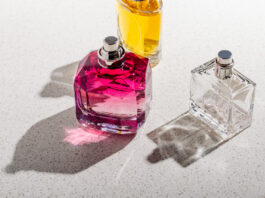 a group of perfume bottles on a white stone background on a sunny day