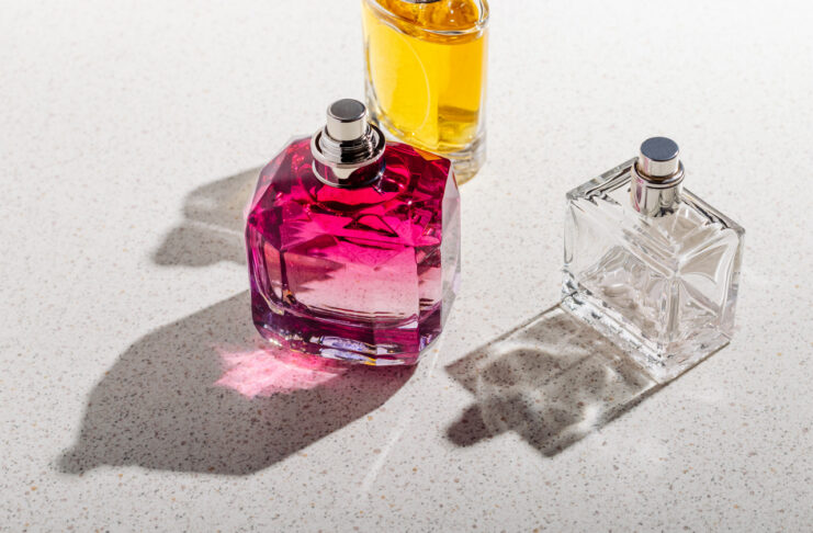 a group of perfume bottles on a white stone background on a sunny day