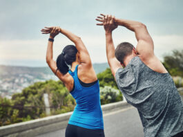 training, couple and stretching arms outdoor in morning for benefits to health, wellness and fitness. people, prepare and start exercise with resilience in summer challenge or flexible muscle in back